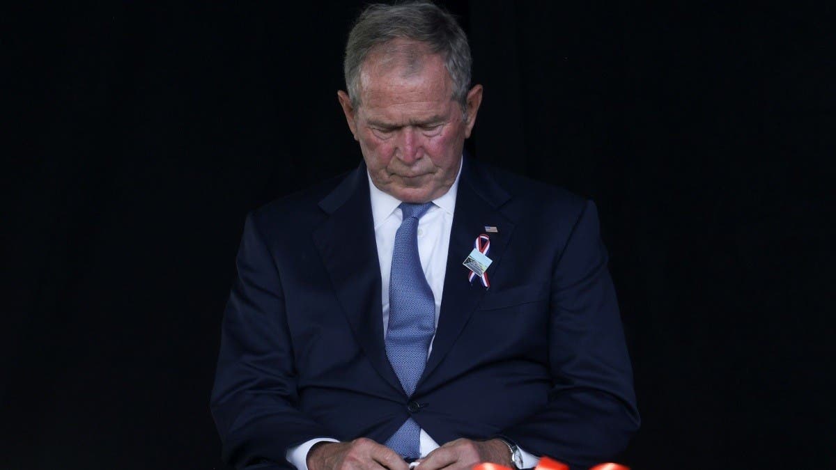 President George W. Bush (C) accepts a football jersey denoting