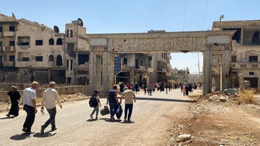 Residents hold their belongings as they return to their neighborhood in Deraa al Balaad, Syria, September 9, 2021. (Reuters)