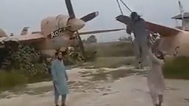 عنصر من طالبان يتأرجح على أحد أجنحة إحدى الطائرات الأميركية