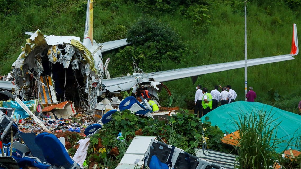 Officials inspect the wreckage of an Air India Express jet at Calicut International Airport in Karipur, Kerala, on August 8, 2020. (AFP)