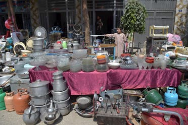 This photo taken on September 12, 2021 shows a young shopkeeper gesturing as he offers secondhand household items for sale at a market in the northwest neighbourhood of Khair Khana in Kabul. (AFP)