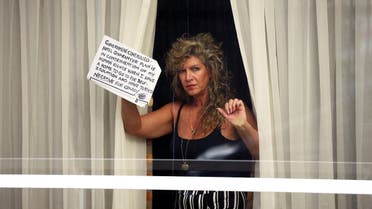 A woman holds a sign at a window of the Radisson Blu Hotel at Heathrow Airport, as Britain introduces a hotel quarantine programme for arrivals from a red list of 30 countries due to the coronavirus disease (COVID-19) pandemic, in London, Britain. (Reuters)