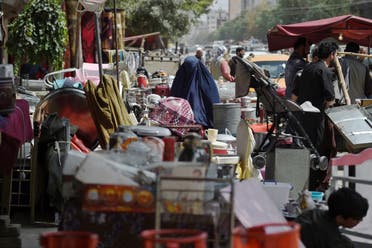 This photo taken on September 12, 2021 shows a woman looking at secondhand household items for sale at a market in the northwest neighbourhood of Khair Khana in Kabul. (AFP)