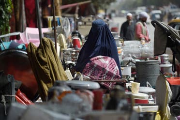 This photo taken on September 12, 2021 shows a woman looking at secondhand household items for sale at a market in the northwest neighbourhood of Khair Khana in Kabul. (AFP)