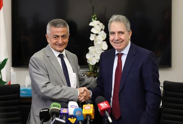 Lebanon’s outgoing Finance Minister Ghazi Wazni shakes hands with the newly appointed Finance Minister Youssef Khalil during a handover ceremony in Beirut, Lebanon September 14, 2021. (Reuters/Mohamed Azakir)