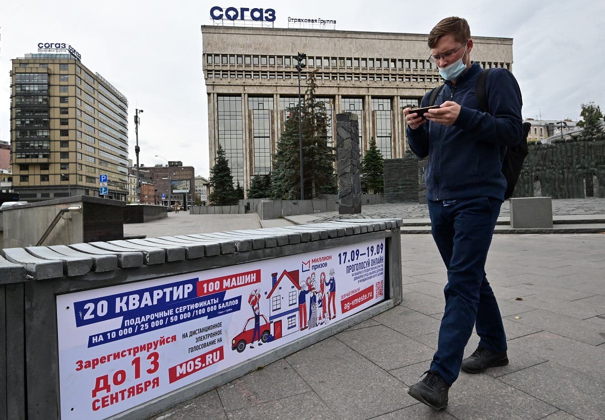 A man walks past a poster announcing the upcoming Russian parliamentary and local elections in Moscow on September 14, 2021. (Yuri Kadobnov/AFP)