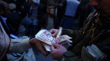 Afghan money changers count banknotes at the currency exchange Sarayee Shahzada market in Kabul on December 17, 2015.  (AFP)