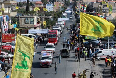 Hezbollah flags flutter as a convoy of tanker trucks carrying Iranian fuel oil arrive at al-Ain village in northeastern Lebanon, September 16, 2021. (Reuters)