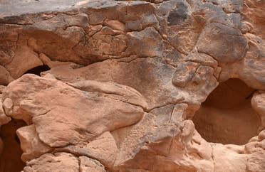 This file photo taken on February 22, 2018, shows the site of an archaeological discovery about eight kilomtres north of the city of Sakaka in Saudi Arabia's northwestern al-Jouf province, with a carved sculpture of a camel's head seen on the right. (AFP)