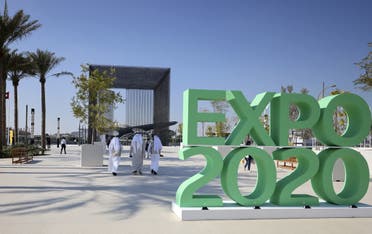 People walk past the official sign marking the Dubai Expo 2020 near the Sustainability Pavilion in Dubai on January 16, 2021. (AFP)