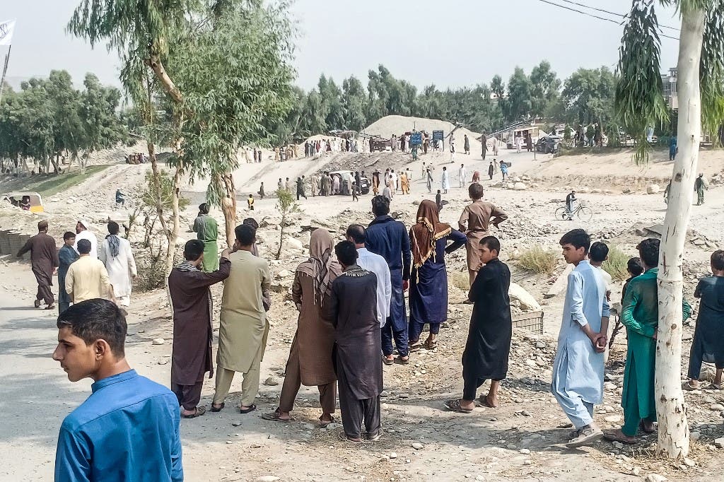 Taliban members and people gather at the site of a bomb explosion which targeted a pickup truck carrying Taliban fighters in Jalalabad on September 19, 2021, a day after at least two people were killed in a series of blasts in the area. (AFP)