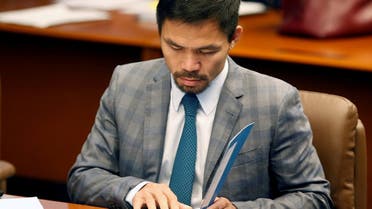 Philippine Senator and boxing champion Manny Pacquiao reads his briefing materials as he prepares for the Senate session in Pasay city, Metro Manila. (Reuters)