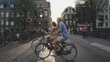 A man and woman cycling in Amsterdam, the Netherlands. (File photo: Unsplash, Sabina Fratila)