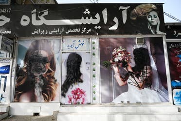 The facade of a beauty salon is pictured with images of women defaced using spray paint in Shar-e-Naw in Kabul on August 18, 2021. (AFP)