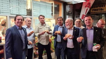 Brazil's President Jair Bolsonaro (3d L) eats pizza with Caixa Economica Federal Bank President Pedro Guimaraes, General Luiz Eduardo Ramos, Tourism Minister Gilson Machado Neto, Health Minister Marcelo Queiroga and other politicians on a street ahead of the United Nations General Assembly in New York City, U.S. September 19, 2021. (Instagram via Reuters)