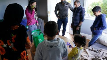 A Vietnamese-American family helps an Afghan family who fled, in Seattle, Sept. 20, 2021. (AP)
