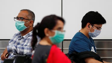 Passengers wearing protective masks sit at an airport terminal following an outbreak of the coronavirus disease (COVID-19), in New Delhi, India, March 14, 2020. (File photo: Reuters)