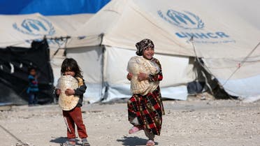 Children holding stacks of bread walk in al-Hol displacement camp in Hasaka governorate, Syria, April 2, 2019. (File photo: Reuters)
