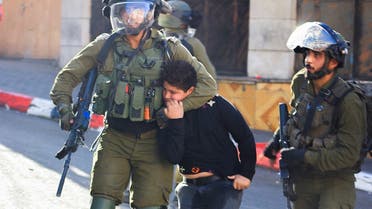 Israeli soldiers detain a Palestinian boy during clashes in Hebron, in the Israeli-occupied West Bank on September 23, 2021. (Reuters)