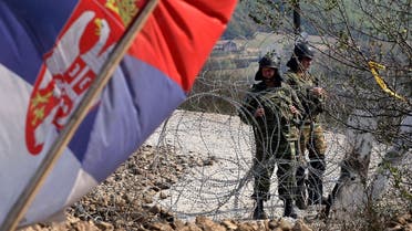 A Serbian flag is seen as the NATO Kosovo Force (KFOR) soldiers stand guard on a barricade at the border crossing Jarinje between Serbia and northern Kosovo on September 28, 2011. (AFP)