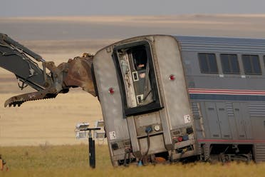 A piece of heavy equipment props up a leaning train car, Sunday, Sept. 26, 2021, that was part of an Amtrak train that derailed Saturday, near Joplin, Montana. (AP)