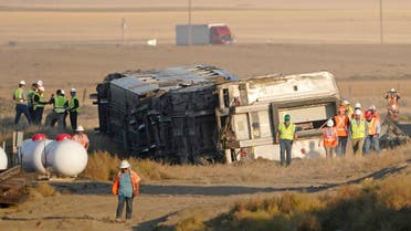 Workers stand Sunday, Sept. 26, 2021, near toppled cars from an Amtrak train that derailed Saturday, just west of Joplin, Mont. The westbound Empire Builder was en route to Seattle from Chicago with two locomotives and 10 cars. (AP)