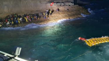 Italian coastguard members rescue 125 migrants who were found stranded on the shores of Isola dei Conigli, a small island close to Lampedusa, Italy, on September 9, 2021. (Reuters)