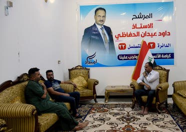 Dawood al-Hafathi, a candidate who participated in protests, sits with his supporters at his home in Nassiriya, Iraq, on September 23, 2021. (Reuters)