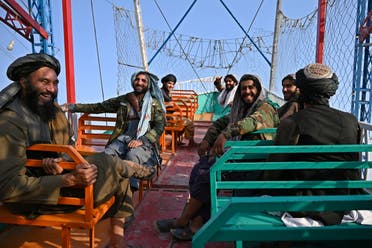 In this photograph taken on September 28, 2021 Taliban fighters enjoy a ride on a pirate ship attraction in a fairground at Qargha Lake on the outskirts of Kabul. (AFP) 