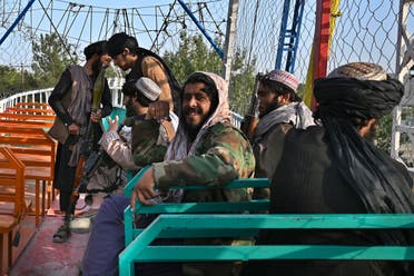 In this photograph taken on September 28, 2021 Taliban fighters enjoy a ride on a pirate ship attraction in a fairground at Qargha Lake on the outskirts of Kabul. (AFP)