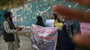 A member of the Taliban speaks with women protestors as another tries to block the view of the camera with his hand during a demonstration held outside a school in Kabul on September 30, 2021. (AFP)