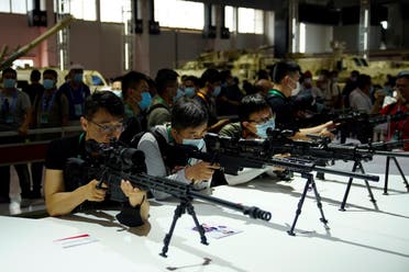 Visitors check on model rifles displayed at the China International Aviation and Aerospace Exhibition, or Airshow China, in Zhuhai, Guangdong province, China September 29, 2021. (Reuters)
