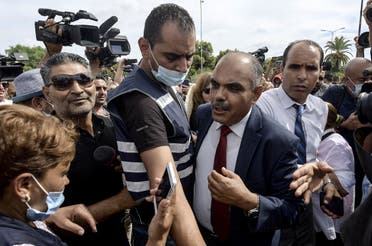 Journalists and members of the security forces surround Mohamed Goumani, a Tunisian deputy and member of the Annahda party, after being attacked by citizens in front of the Assembly headquarters, during a rally in the capital Tunis on October 1, 2021. (Fethi Belaid/AFP)