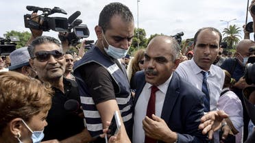 Journalists and members of the security forces surround Mohamed Goumani, a Tunisian deputy and member of the Annahda party, after being attacked by citizens in front of the Assembly headquarters, during a rally in the capital Tunis on October 1, 2021. (Fethi Belaid/AFP)