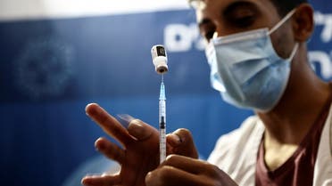 A nurse prepares a syringe to give a third dose of the coronavirus disease (COVID-19) vaccine, in Jerusalem, October 3, 2021. (Reuters)