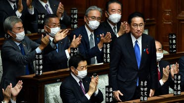 Leader of Japan's rulimg Liberal Democratic Party (LDP) Fumio Kishida (C) is applauded after being elected as new prime minister at the lower house of parliament in Tokyo on October 4, 2021