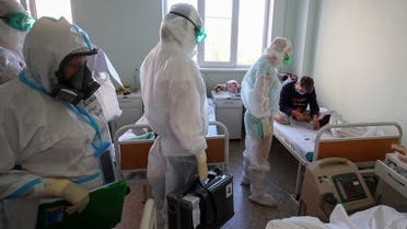 Members of a local election commission wearing personal protective equipment (PPE) and carrying a mobile ballot box and documents visit patients suffering from the coronavirus disease (COVID-19) during the Russian parliamentary election at the red zone of a hospital for war and labour veterans in Volgograd, Russia September 17, 2021. (Reuters)
