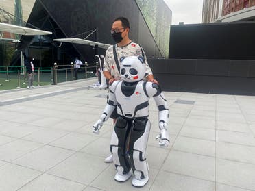 A man stands next to a panda robot at the Chinese Pavilion at the Expo 2020 in Dubai, UAE, on October 4, 2021. (Reuters)