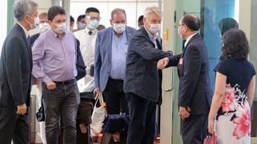 French senator Alain Richard bumps elbows with a Taiwanese official upon arrival at the Taoyuan International Airport in Taiwan on Oct. 6, 2021.  (AP)
