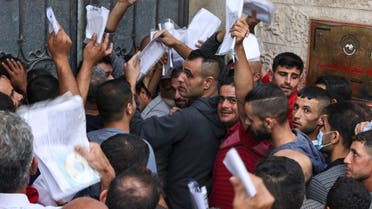 Palestinian men gather to apply for work permits in Israel, at Jabalia refugee camp in the northern Gaza Strip, on October 6, 2021. (Mahmud Hams/AFP)