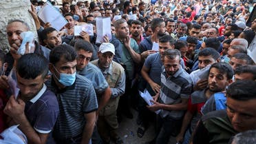 Palestinian men gather to apply for work permits in Israel, at Jabalia refugee camp in the northern Gaza Strip, on October 6, 2021. (Mahmud Hams/AFP)