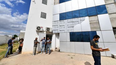 Employees gather outside the building housing the Zitouna TV channel on October 6, 2021, in the district of Mghira of greater Tunis, the country's capital. (Fethi Belaid/AFP)