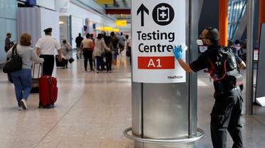 A worker sanitises a sign at the International arrivals area of Terminal 5 in London's Heathrow Airport, Britain. (Reuters)