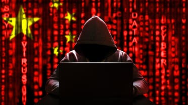 Chinese hacker at the computer, on a background of binary code, the colors of the Chinese flag. (Stock Photo)