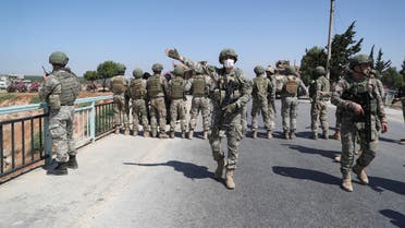 Turkish soldiers stand guard on a bridge overlooking a section of the M4 highway, which links the northern Syrian provinces of Aleppo and Latakia, during a joint Russian-Turkish military convoy near Ariha in Syria's rebel-held northwestern Idlib province, on June 10, 2020.