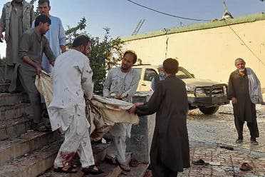 Afghan men carry the dead body of a victim to an ambulance after a bomb attack at a mosque in Kunduz on October 8, 2021. (AFP)