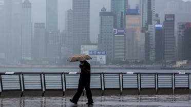 A man walks in the rain along Victoria Harbour in the Kowloon district of Hong Kong on August 16, 2021. (File photo; AFP)