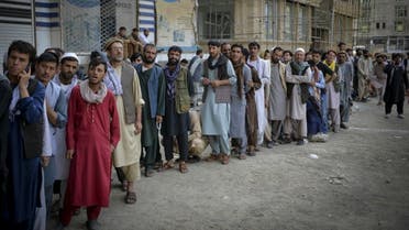 Afghans queue up as they wait for the banks to open and operate at a commercial area in Kabul on August 31, 2021. (AFP)
