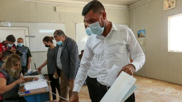 Darwesh Khodeda Hassan, a displaced Yazidi man, casts his vote at a polling station, two days ahead of Iraq's parliamentary elections in a special process, at the Sharya camp in Duhok, Iraq, October 8, 2021. (Reuters)