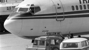 A Shiite Muslim hijacker points his pistol toward an ABC news media crew from the window of the cockpit of the Trans World Airlines jet at Beirut International Airport, June 19, 1985. (AP)